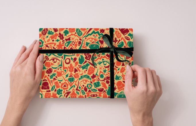 Papel de regalo colorida con un lazo negro sobre una superficie clara. Campaña publicitaria, diseño grafico, ilustración.