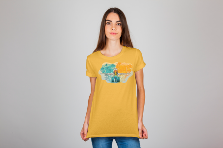 Mujer con camiseta amarilla con una ilustración, diseño colorido en el pecho, posando frente a un fondo claro.